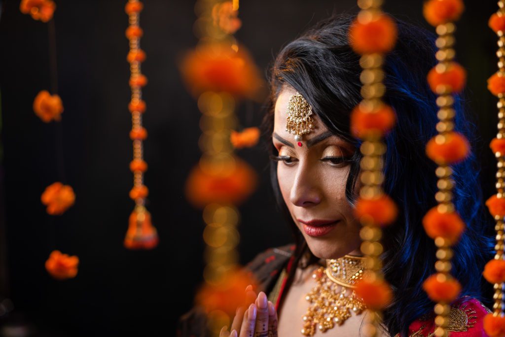 indian woman wearing traditional attire and hiding in beads