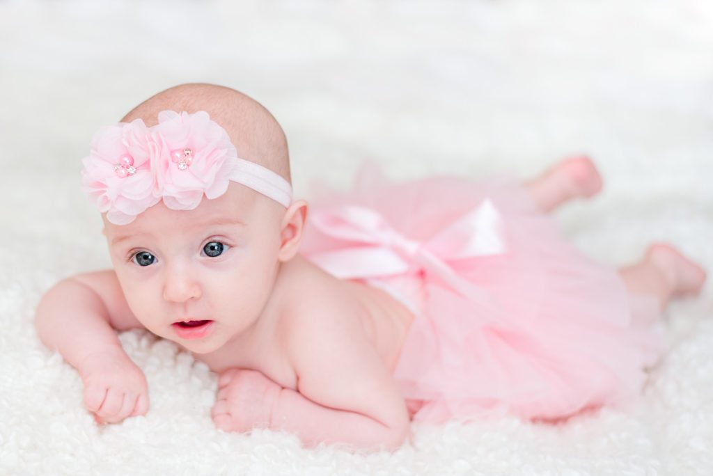 Annessa at 3 months smiling and wearing a pink tutu