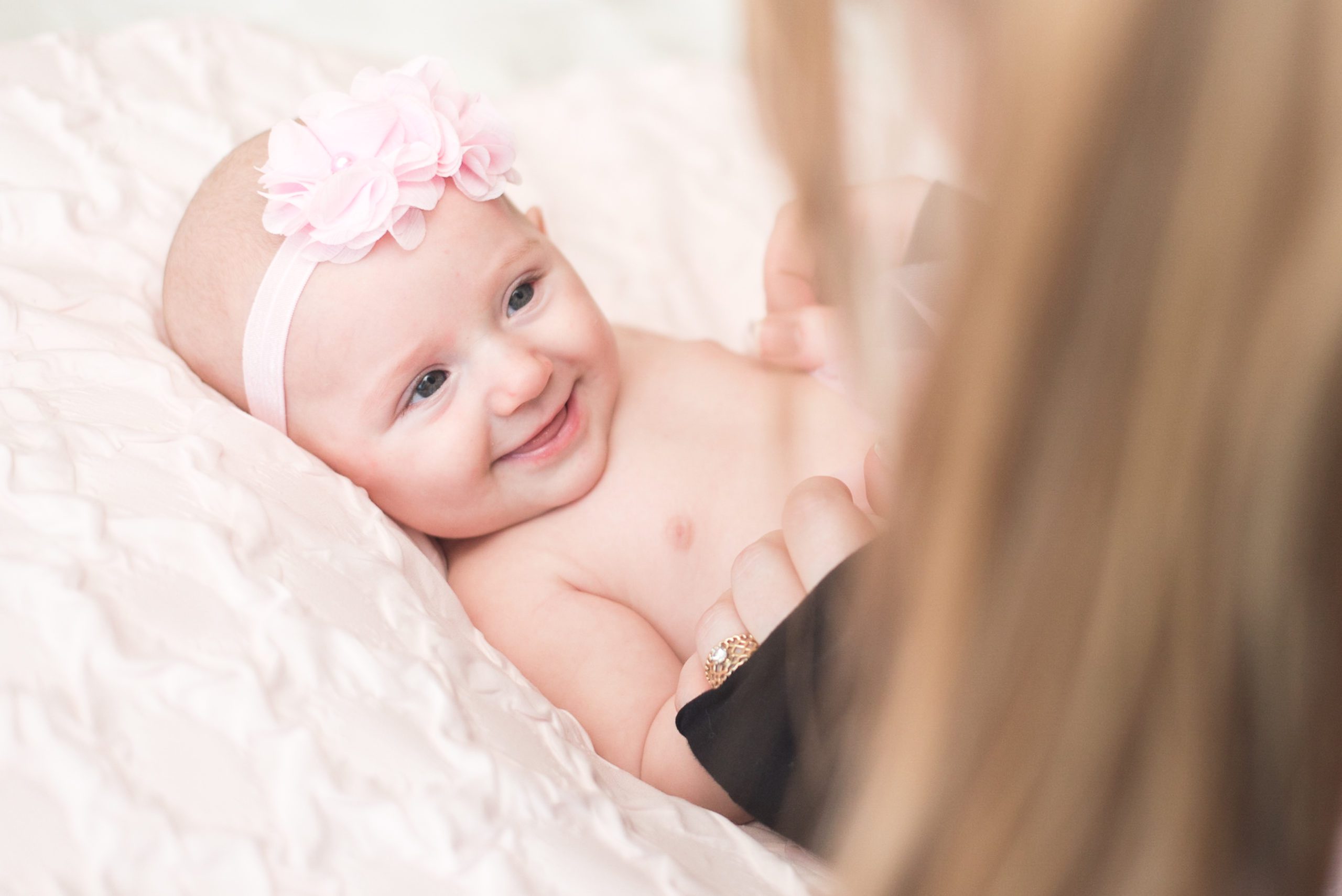 Annessa at 3 months smiling at her mom and wearing a pink tutu