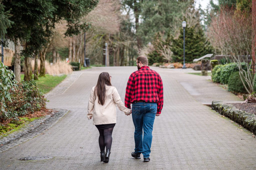 Engaged couple walking down path at Lewis and Clark College