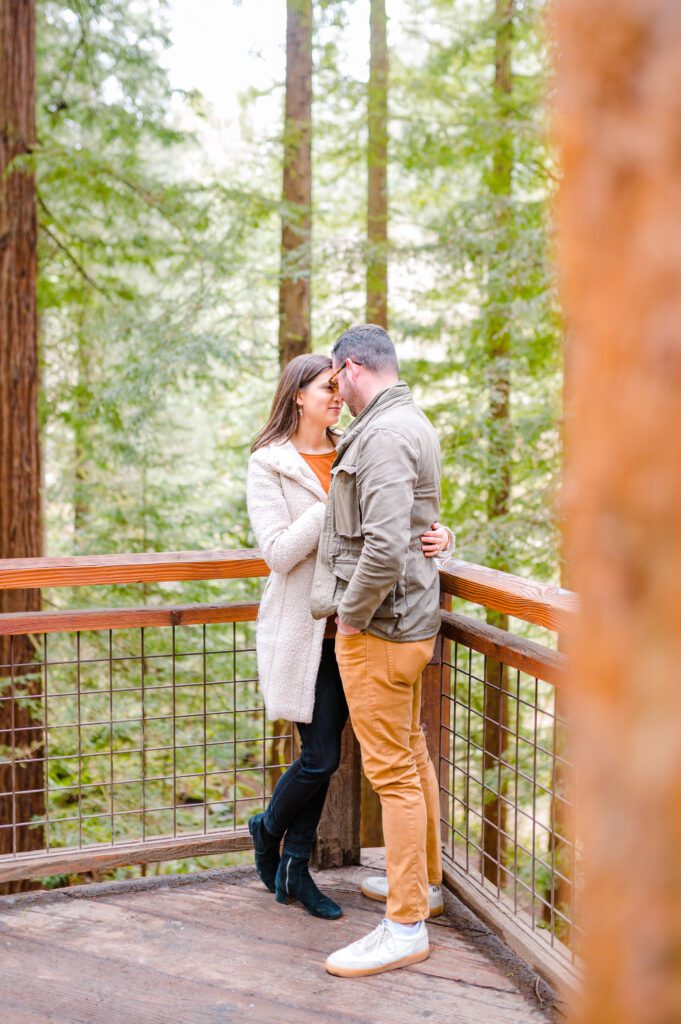 Engaged couple on deck in woods