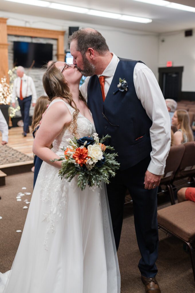 Wedding recessional in Oregon where bride and groom stop to share a kiss