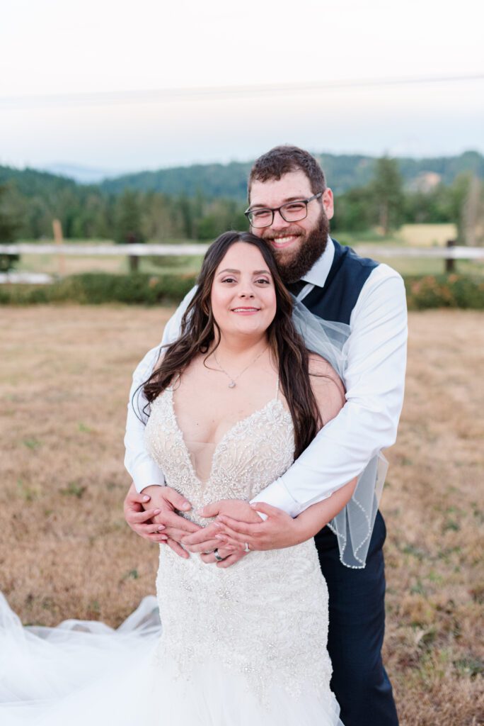 Bride and groom posing in a field at East Fork Country Estate in Damascus Oregon