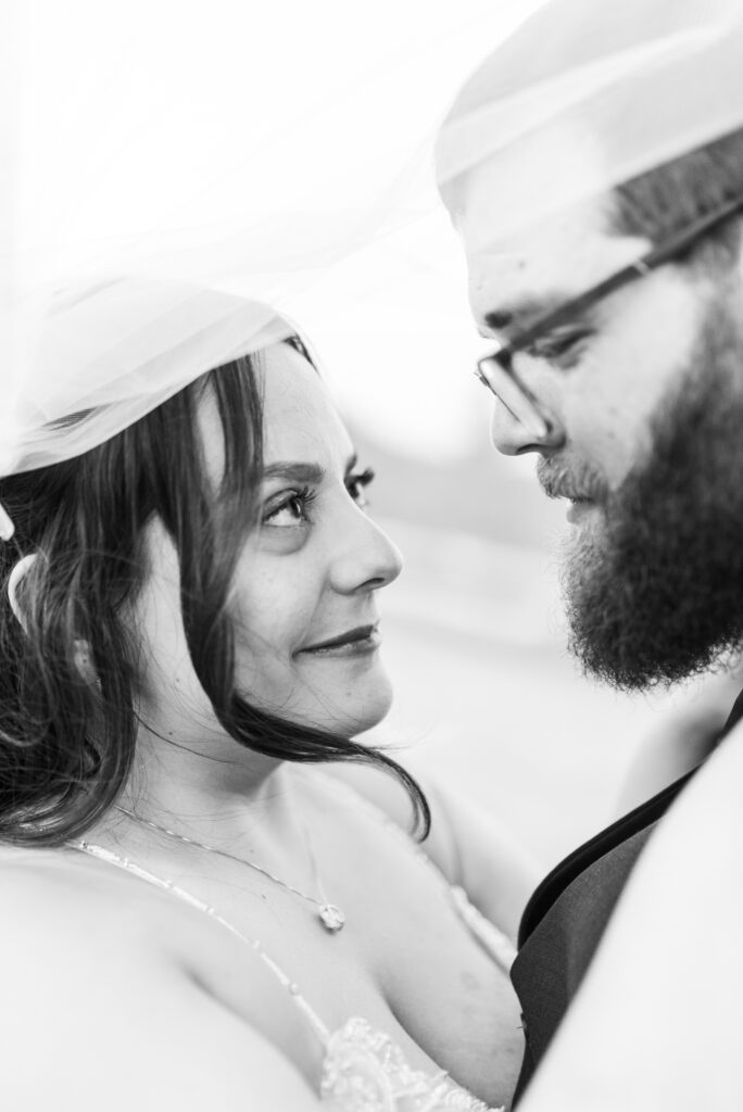 Bride and groom looking at each other under veil at East Fork Country Estate in Damascus Oregon