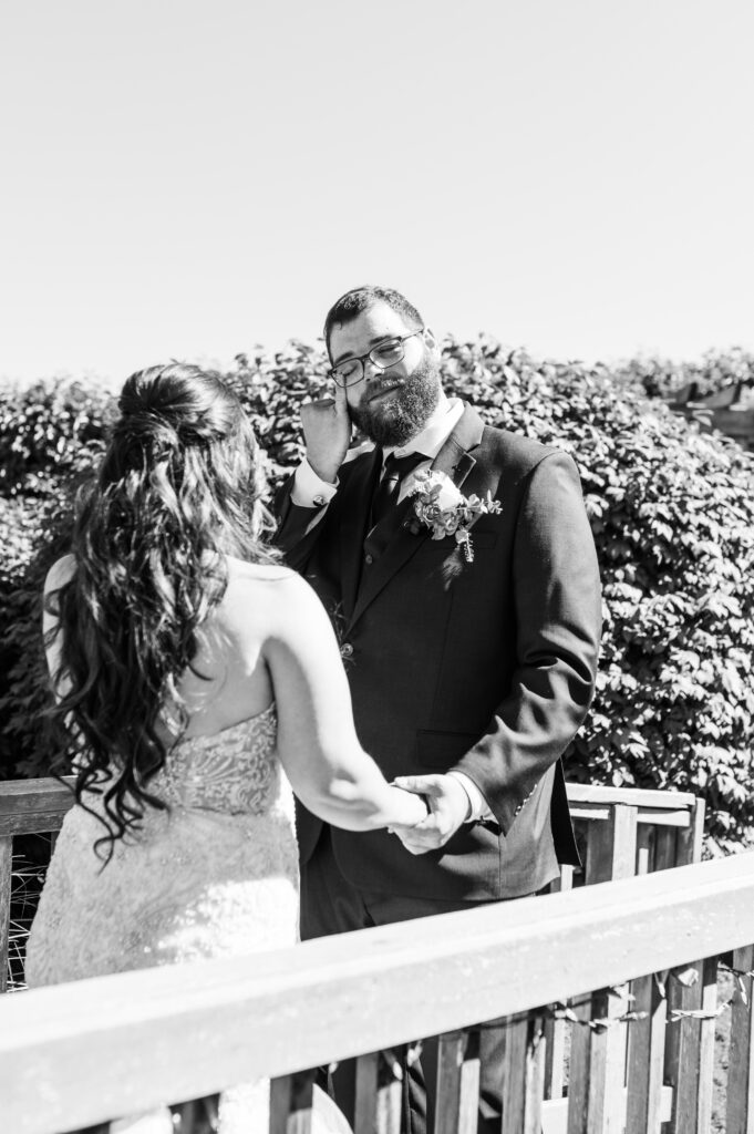 Groom wiping a tear away during the first look at East Fork Country Estate in Damascus Oregon