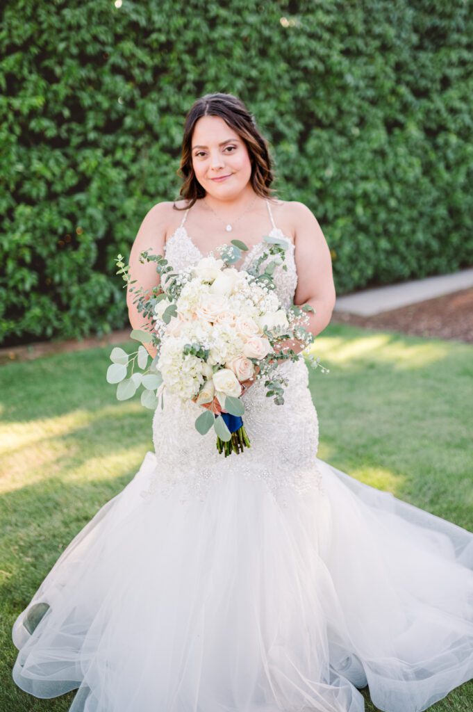 Bride holding her wedding bouquet with white, champagne and soft pinks at her wedding at East Fork Country Estate in Damascus Oregon