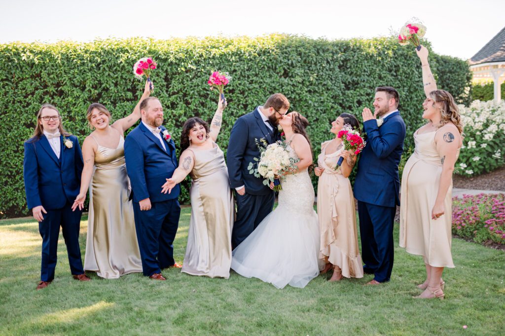 Wedding party fun pose with pink bouquets in the air at East Fork Country Estate in Damascus Oregon