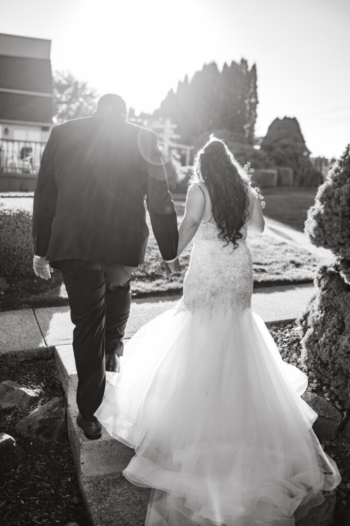 Couple walks towards their wedding venue at East Fork Country Estate in Damascus Oregon in the sunset