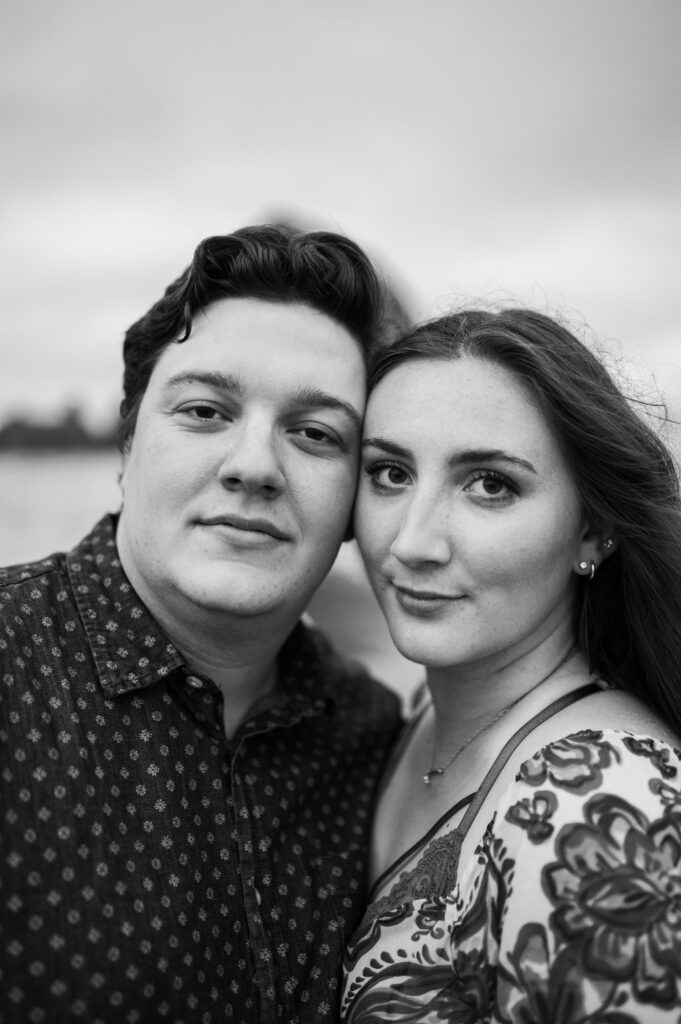 black and white image of couple temple to temple at their engagement session in cannon beach oregon